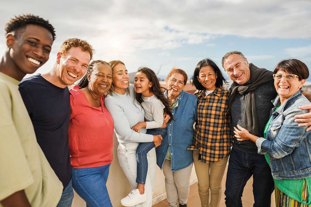 group of multicultural, multigenerational people smiling together at the camera